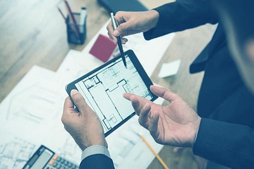 Two people reviewing a floorplan on a tablet
